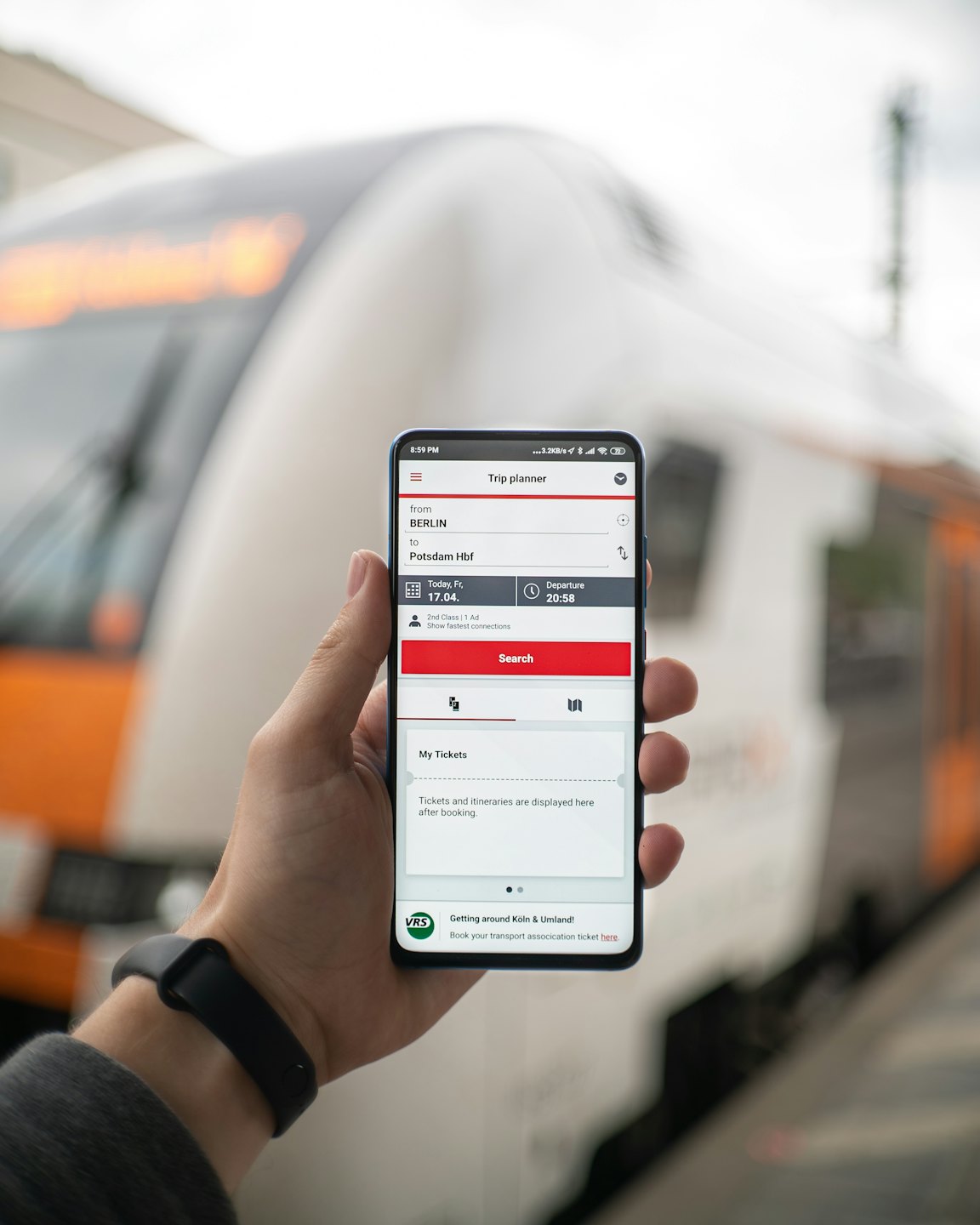 Hand som håller en telefon med en tågbiljettapp.