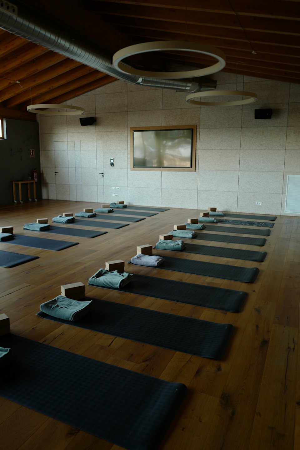 Yogastudio med mattor, block och handdukar prydligt arrangerade.